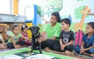 Young children sit with a dog