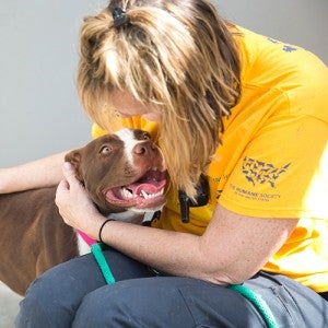 HSUS volunteer cuddling with a dog