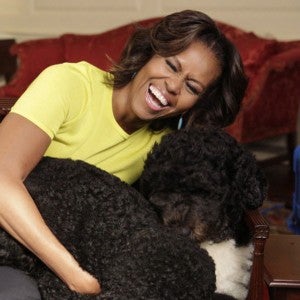 Former First Lady Michelle Obama plays with family dog Bo