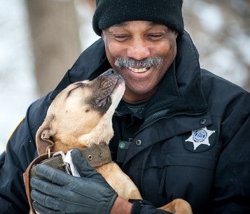 Animal control officer smiling with happy pit bull