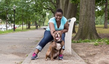 Woman sitting with dog at park. 