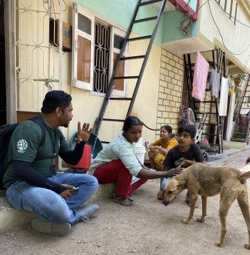 A group of people greet a dog on the street