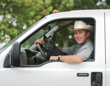 George W Bush drives a truck while Barney sits on his lap