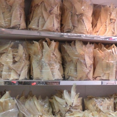 Dried bags of shark fins for sale and shark fin soup on the menu