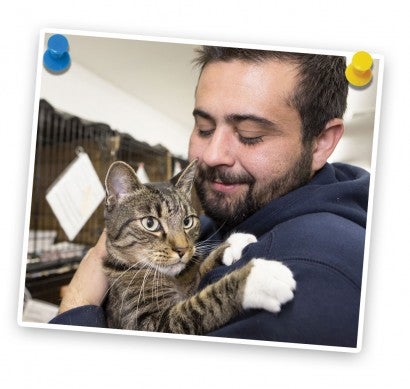 Man holding cat in shelter