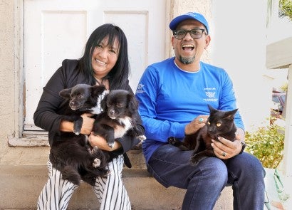 Robert Sotelo visits with Pets for Life client Karina Lopez, her two dogs, and a cat.
