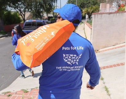 Robert Sotelo, manager of the Pets for Life program carries food to be donated