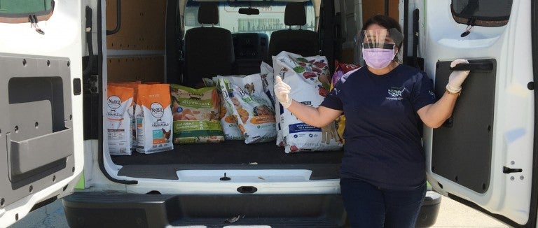 Pets for Life staff member with a van full of supplies