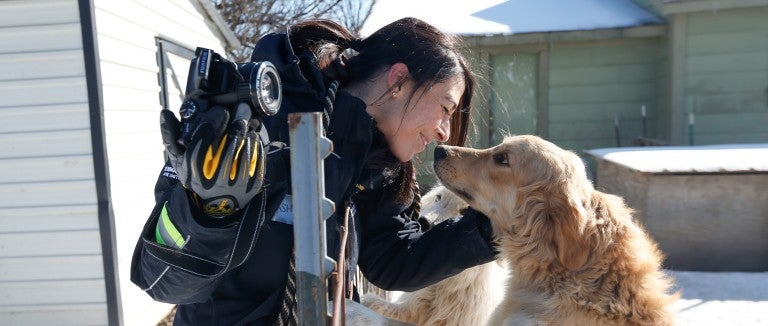 Intern Ashley Mauceri rubs noses with a dog